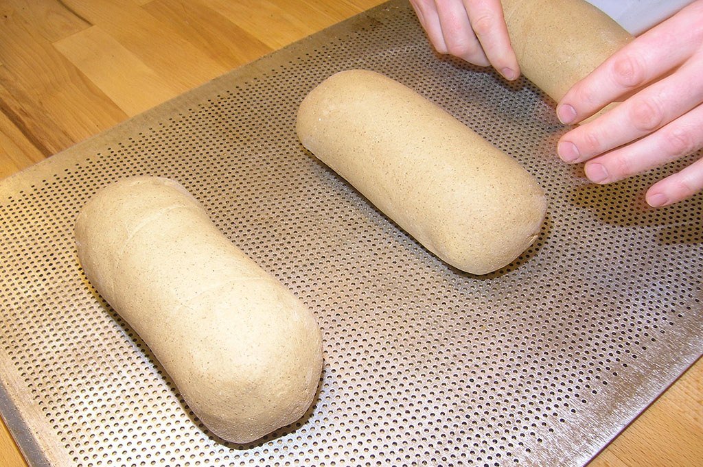 Un apprenti boulanger pétrit le pain